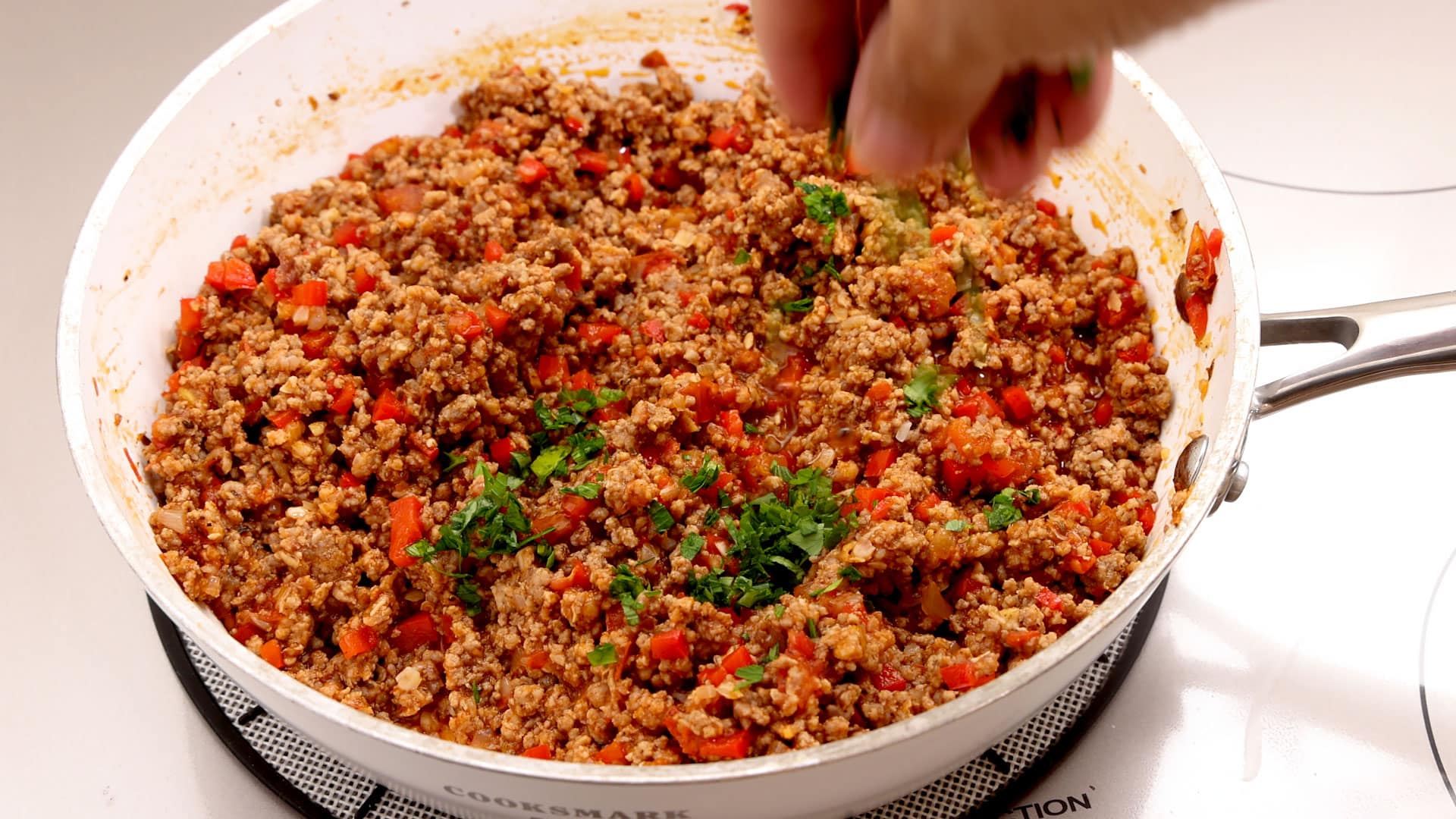 Sprinkling parsley on the meat.