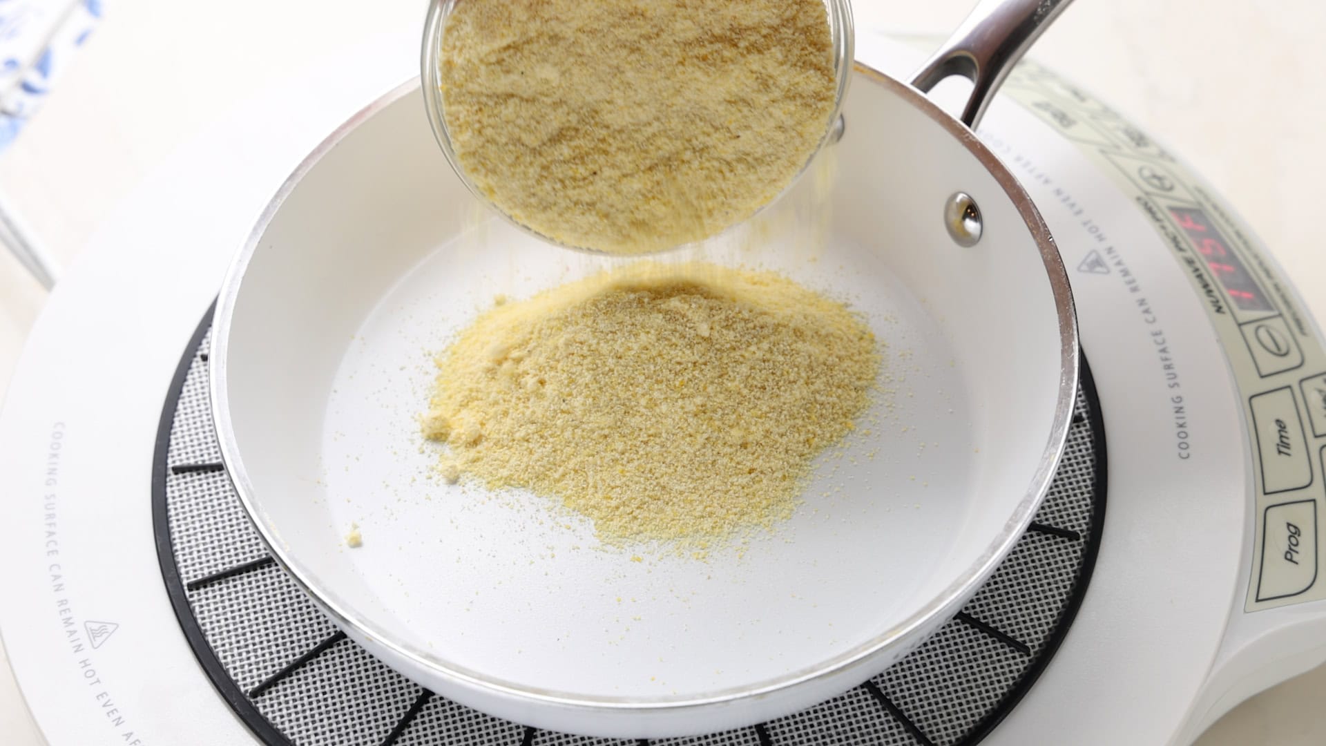 Pouring cornmeal into pan.