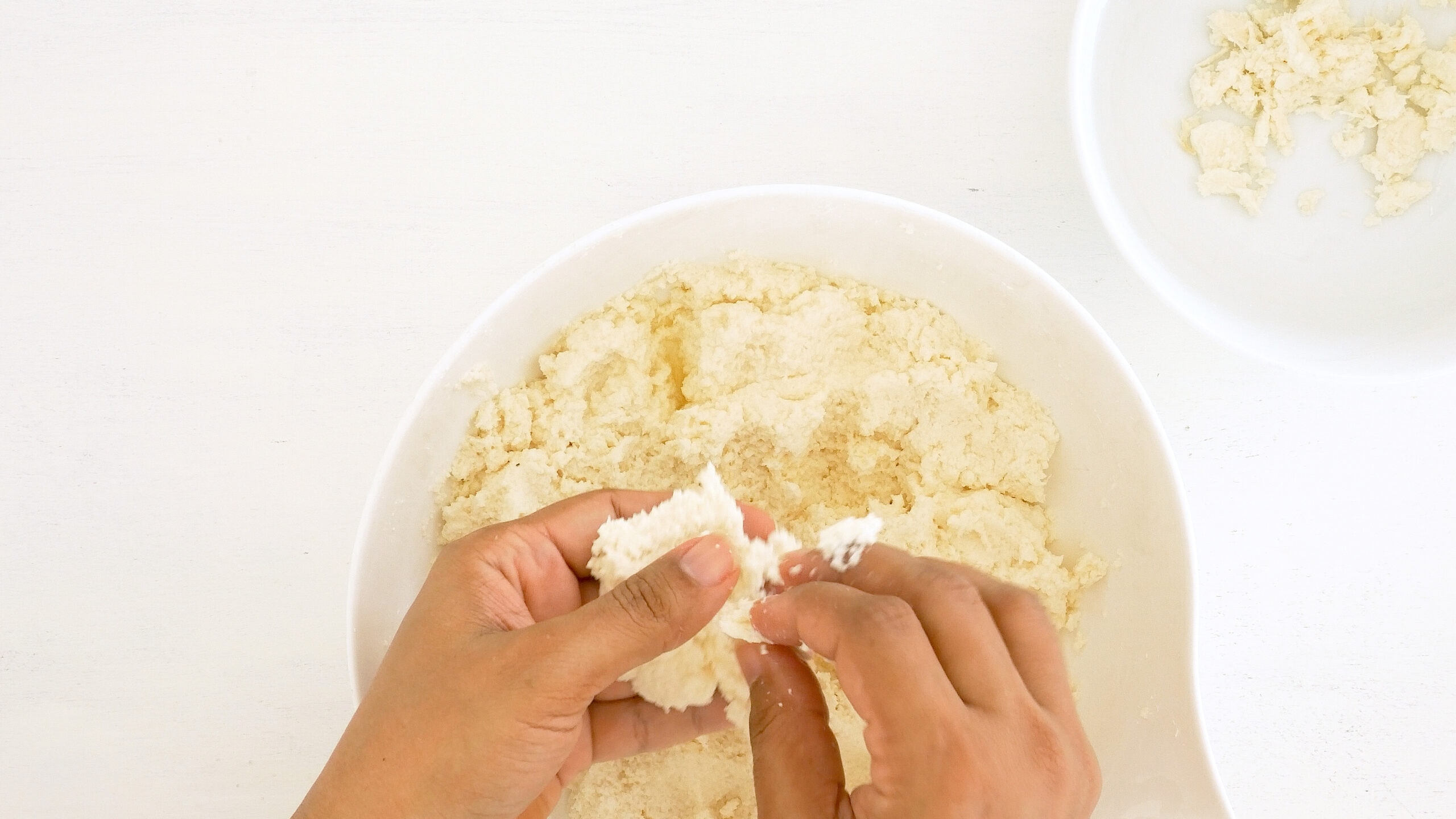 Breaking clumps from grated yuca.