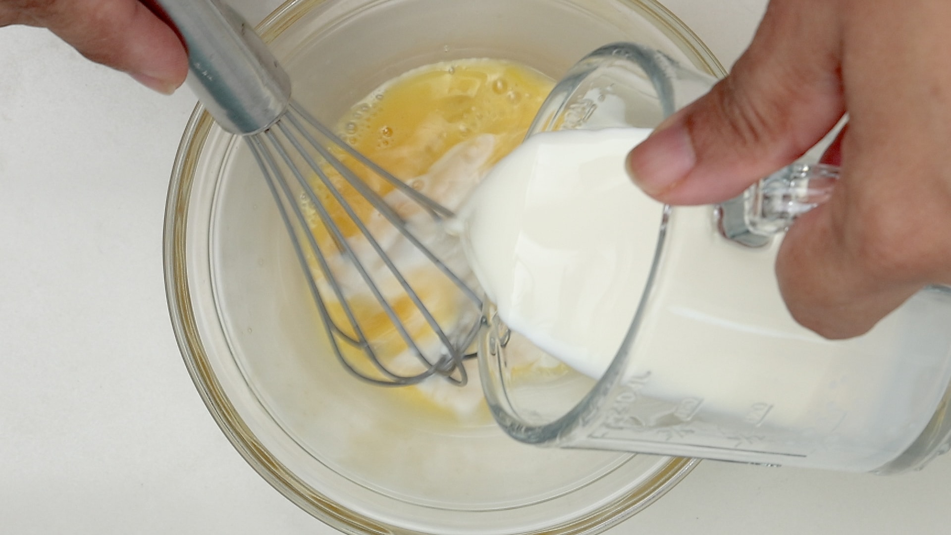 Combining egg and milk.