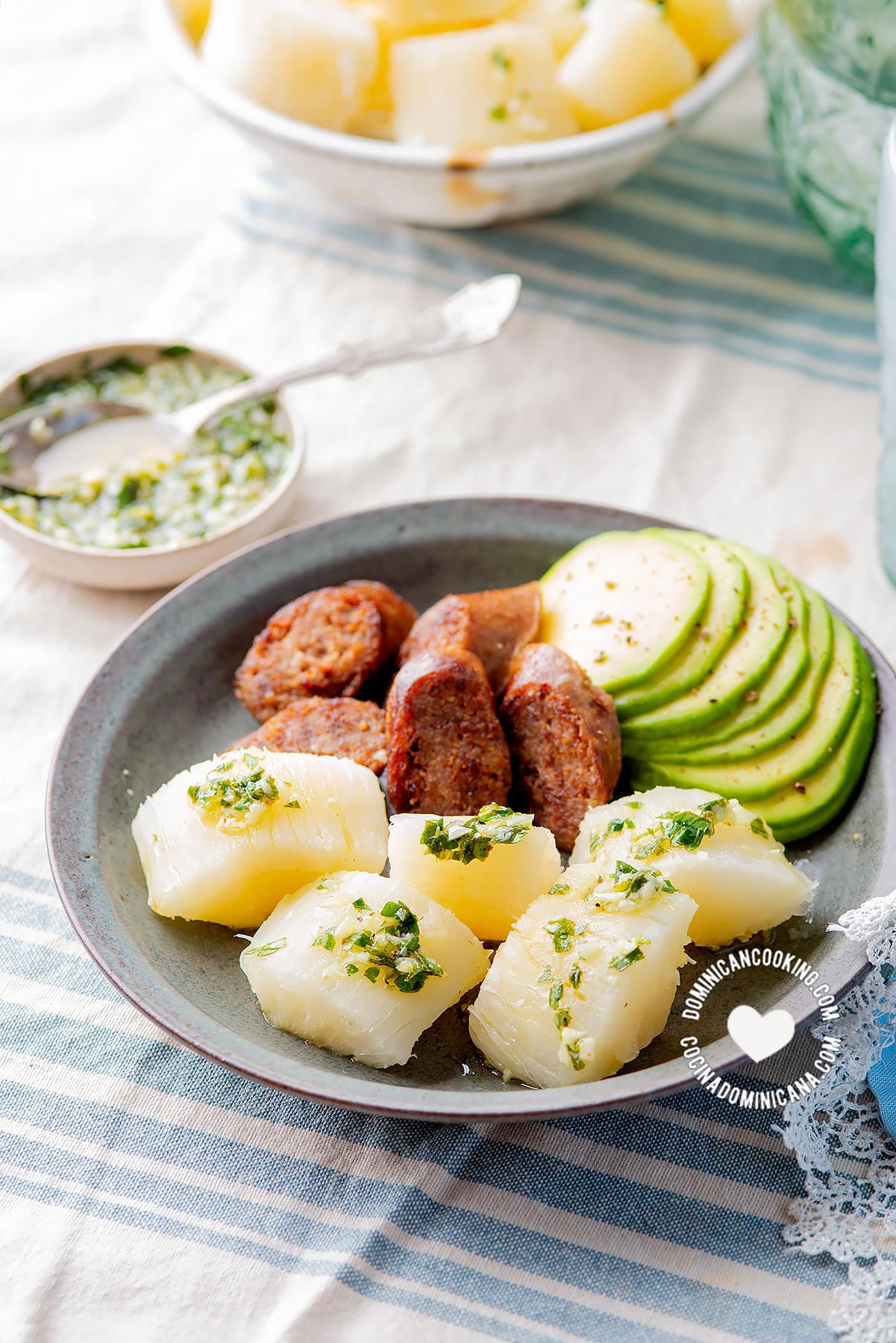 Yuca al mojo de ajo (cassava with garlic sauce) served with avocado and longaniza.